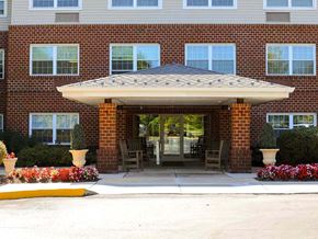 Upper Chichester apartment for rent - the front entrance of a brick building with a patio umbrella