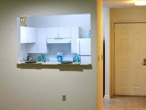 York apartment for rent - a kitchen with white cabinets and a counter with blue glasses