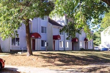 Columbia apartment for rent - a white building with red awnings and a tree in front of it