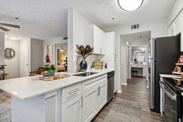 Duluth apartment for rent - A kitchen with white cabinets and a black fridge.