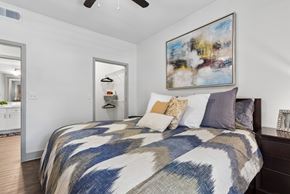 Round Rock apartment for rent - A bedroom with a large bed and a painting on the wall.