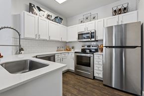 Round Rock apartment for rent - A kitchen with white cabinets and a stainless steel refrigerator.