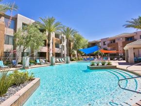 Phoenix apartment for rent - a large swimming pool with palm trees and buildings