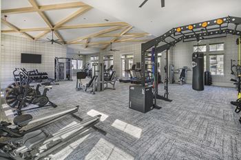 A gym with a variety of equipment including treadmills, weights, and exercise machines