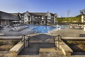 Flowery Branch apartment for rent - A large building with a pool in front at Folksong Apartments, Flowery Branch, GA 30542