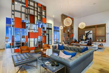 Orlando apartment for rent - A modern living room with a grey sofa and a glass partition.