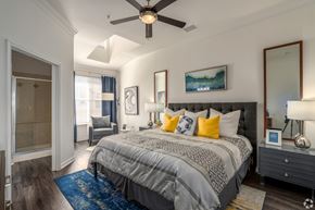Round Rock townhouse for rent - A bedroom with a large bed and a ceiling fan.