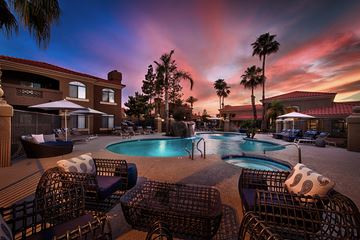 Chandler apartment for rent - a swimming pool at sunset at a resort with chairs and umbrellas