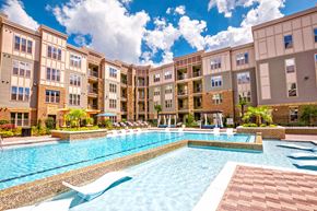 Alpharetta apartment for rent - a swimming pool with lounge chairs and umbrellas in front of an apartment building at Artesia Big Creek, Alpharetta, GA, 30005