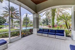 Tampa apartment for rent - Outdoor resident lounge with blue sectional couch for seating and oversized windows at Tuscany Bay Apartments, Florida