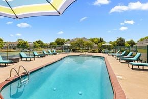 Millville apartment for rent - A large swimming pool with a blue tinted water and a white fence around it.