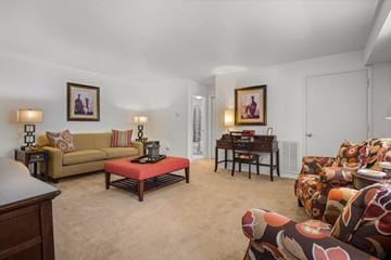 Millville apartment for rent - A living room with a couch, a coffee table, and a painting on the wall.