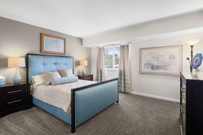 Carneys Point apartment for rent - A bedroom with a blue bed and a painting on the wall.