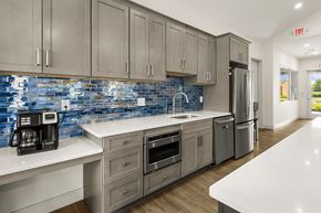 Carneys Point apartment for rent - A kitchen with a white counter top and a blue tile backsplash.
