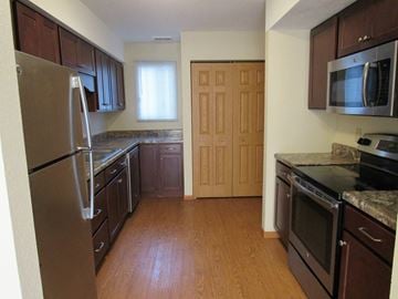 Brooklyn Center townhouse for rent - a kitchen with stainless steel appliances and wooden floors