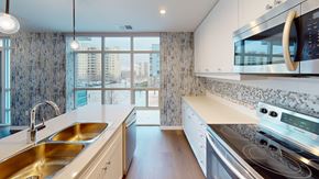 London apartment for rent - A modern kitchen with a stainless steel stove and a double sink.
