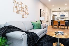 London apartment for rent - a living room with a gray couch and a dining room table
