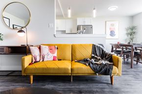 London apartment for rent - A yellow couch with a black blanket on it.