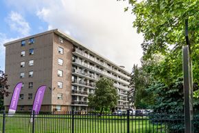 London apartment for rent - A tall building with balconies and flags in front of it.