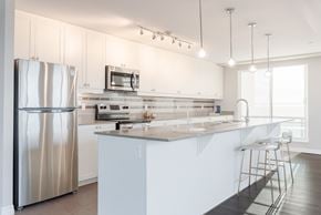 London apartment for rent - A modern kitchen with a stainless steel refrigerator and white cabinets.