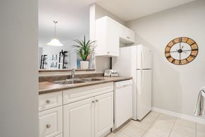 London apartment for rent - a kitchen with white cabinets and a sink and a refrigerator