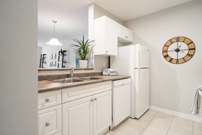 London apartment for rent - a kitchen with white cabinets and a sink and a refrigerator
