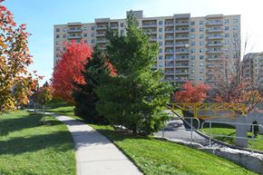 London apartment for rent - a sidewalk winding through a park with trees and tall buildings
