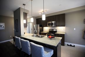 London apartment for rent - a kitchen with a island with four stools and a stainless steel refrigerator