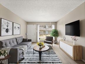 Lafayette apartment for rent - A living room with a grey couch, a coffee table, a chair, a plant, and a flat screen TV mounted on the wall.