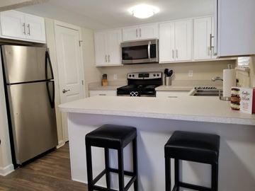 Lafayette apartment for rent - A kitchen with white cabinets and a stainless steel refrigerator.