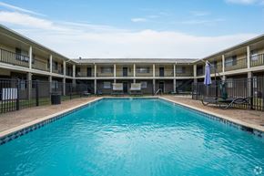 Lafayette apartment for rent - A swimming pool in front of a building with balconies.