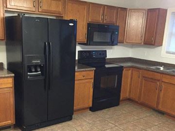 Erie apartment for rent - a kitchen with black appliances and wooden cabinets