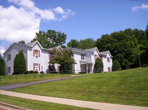 Meadville apartment for rent - a white house with red shuttered windows on a hill