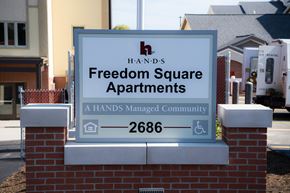 Erie townhouse for rent - a sign for freedom square apartments in front of a house