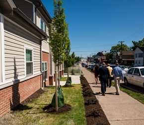 Erie townhouse for rent - people walking down the sidewalk in front of a house