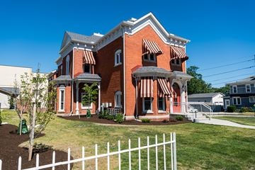 Erie apartment for rent - a red brick house with a white fence in front of it