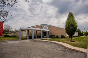 Erie apartment for rent - the front of a brick building with a covered parking lot