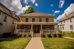 Meadville apartment for rent - the front of a brick house with a porch and a sidewalk