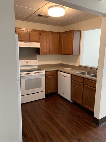 Erie apartment for rent - an empty kitchen with white appliances and wooden cabinets