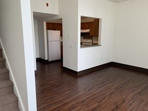 Erie apartment for rent - an empty living room with wood flooring and a kitchen