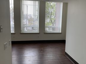 Erie apartment for rent - an empty living room with wood floors and large windows
