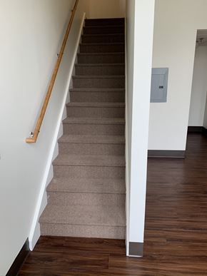 Erie apartment for rent - a view of the stairs from the bottom of a staircase with carpet and wood floors