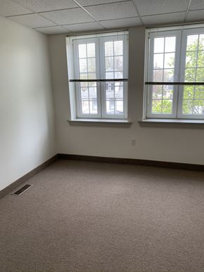 Erie apartment for rent - an empty room with three windows and a carpeted floor
