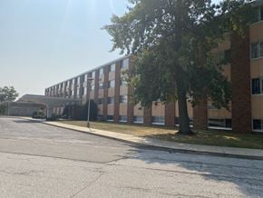 Erie apartment for rent - a large brick building with a tree in front of it