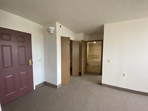 Erie apartment for rent - a view of a living room and a hallway with a purple door