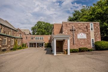 Erie apartment for rent - the front of a brick building with a driveway and a white entrance