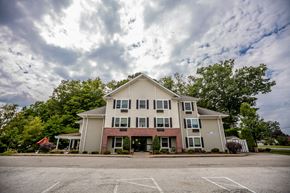 Waterford apartment for rent - an apartment building with a parking lot and a cloudy sky
