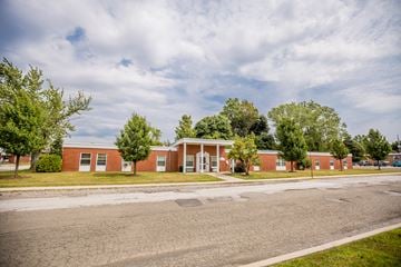 Erie apartment for rent - a brick building with trees in front of it and a road
