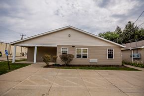 Erie apartment for rent - a small tan house with a driveway in front of it