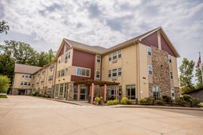 Erie apartment for rent - the exterior of a building with an flag and a parking lot